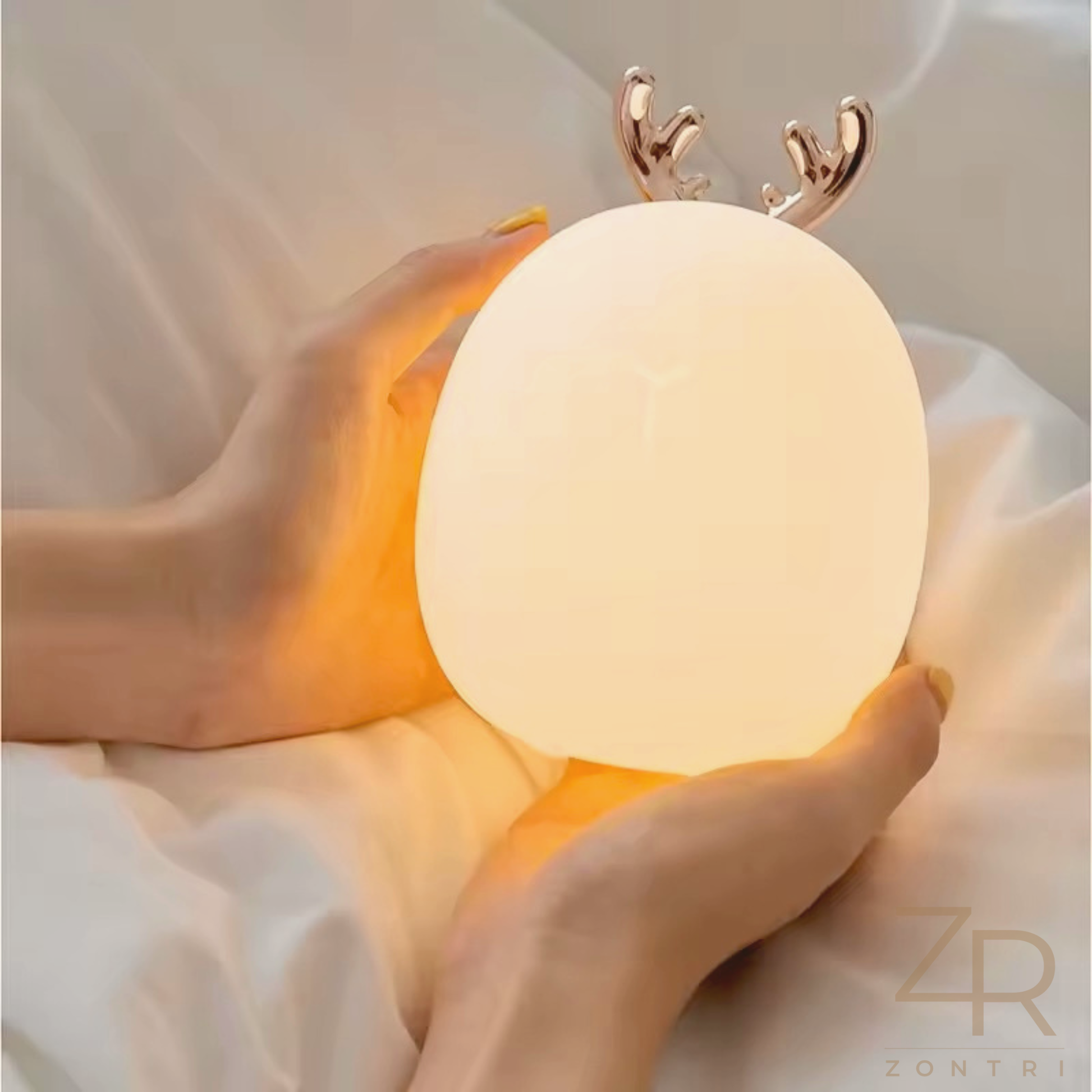 Happy girl lying in bed, smiling at a glowing bunny night light that creates a comforting bedtime atmosphere.